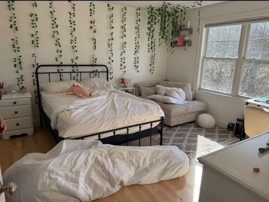 Bedroom with unmade bed and linens on the floor before service